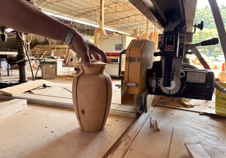Craftsman shaping a wooden cremation urn in the Royal Memorials workshop, showcasing quality and durability.