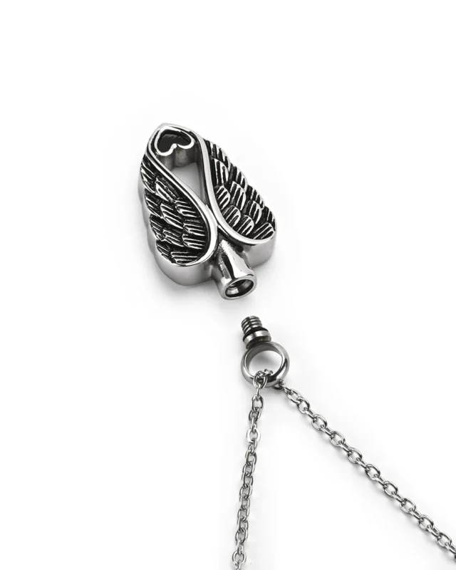 Top view showing unscrewed top bail with rubber gasket seal and inner chamber of angel wings heart cremation necklace