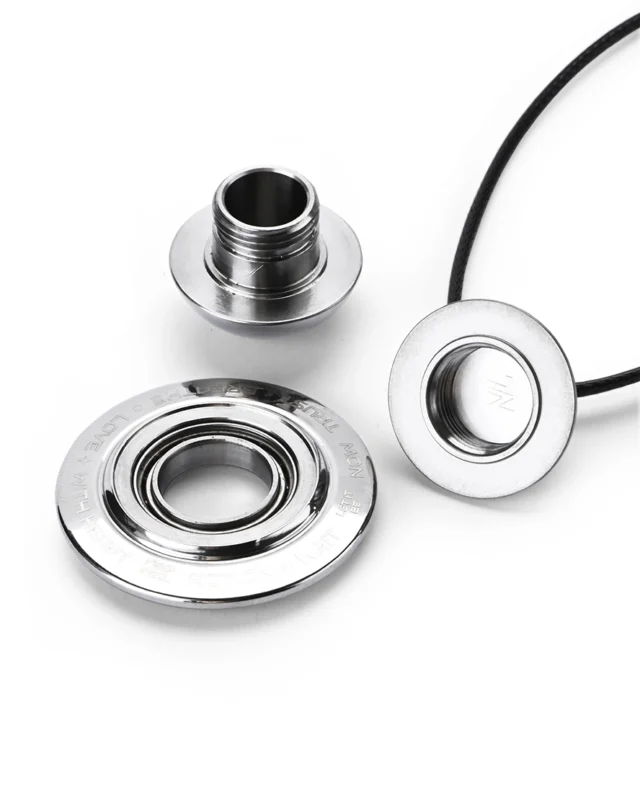 Disassembled polished titanium cremation necklace showing the threaded waterproof memory chamber and smooth ball bearing
