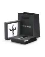 Angel wings cross stainless steel necklace displayed in a floating presentation frame with gift bag