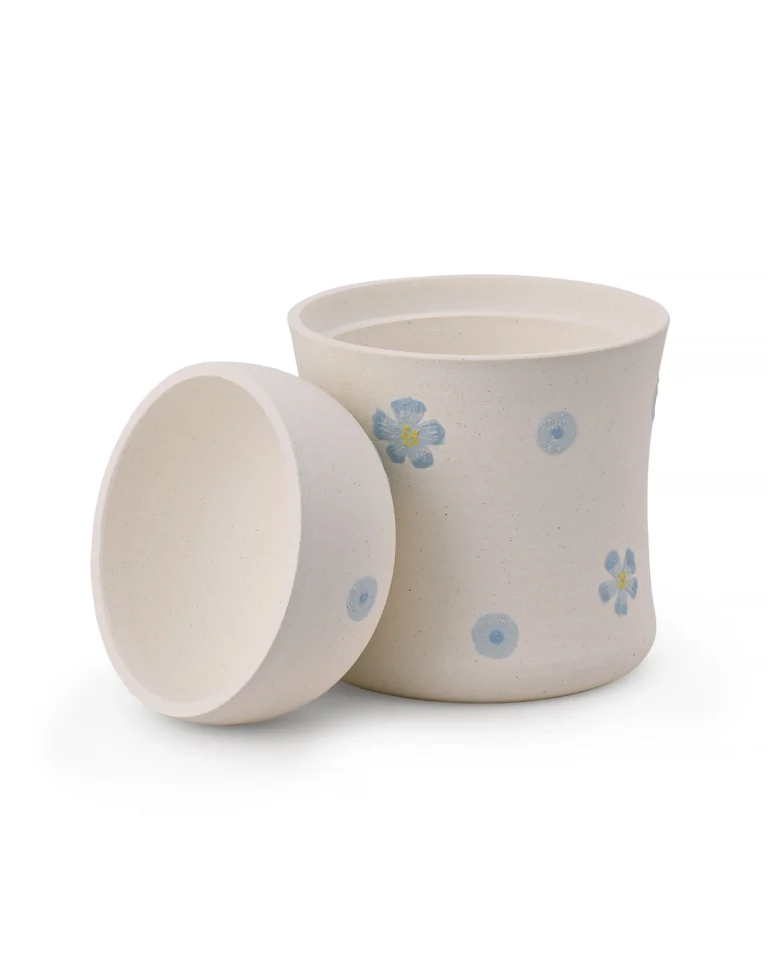 Blue floral ceramic pet urn with its dome-shaped lid removed, showing the top opening and interior chamber