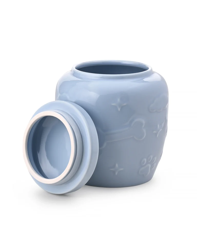 Light blue ceramic pet urn with removable lid placed beside the open top, showing the interior and raised bone and paw details