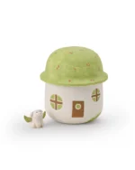 Mushroom house ceramic pet urn with a green roof, brown door, and round windows, shown beside a winged dog figurine