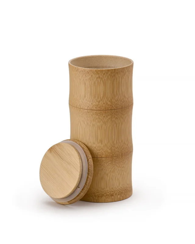 Three-section natural bamboo pet urn with removable lid placed beside the open cylindrical chamber, showing the fitted sealing ring