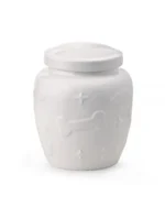 White ceramic pet urn with glossy glaze and raised paw prints, bones, clouds, and stars