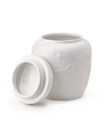 White ceramic pet urn with raised patterns and removable top lid shown beside the opening