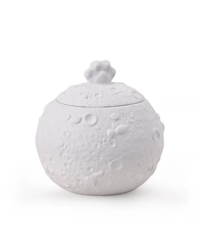 Round white ceramic pet urn with moon-like circular surface texture and a paw-shaped handle on the removable dome lid