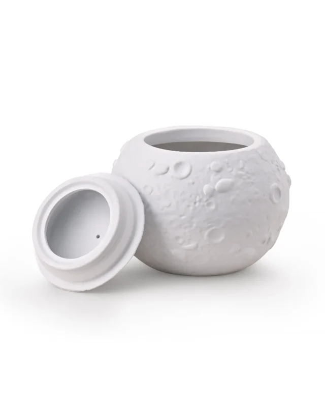 White moon-textured ceramic pet urn with removable dome lid beside the top opening, showing the interior chamber